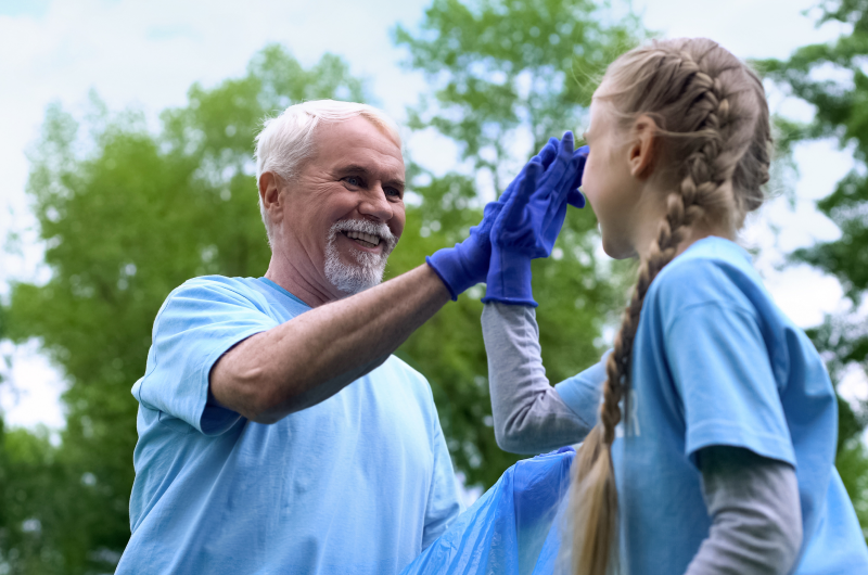 Older volunteer high five young volunteer