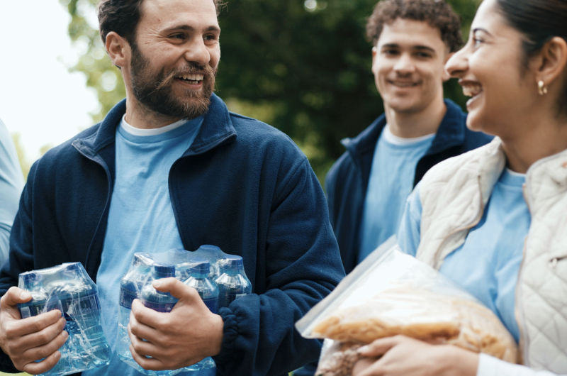 3 volunteers carrying food and supplies