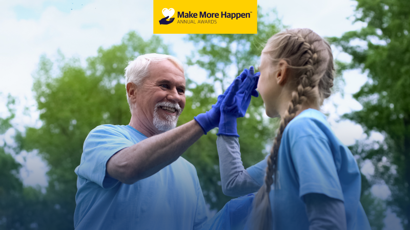 Older volunteer high five younger volunteer